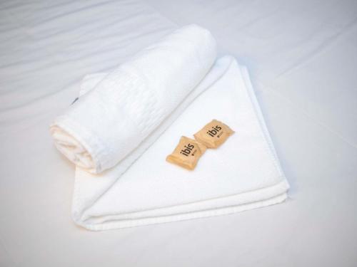 a white towel with two pillows on a bed at ibis budget Divinopolis in Divinópolis