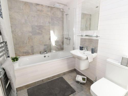 a bathroom with a tub and a sink and a toilet at Kingfisher in Ross on Wye