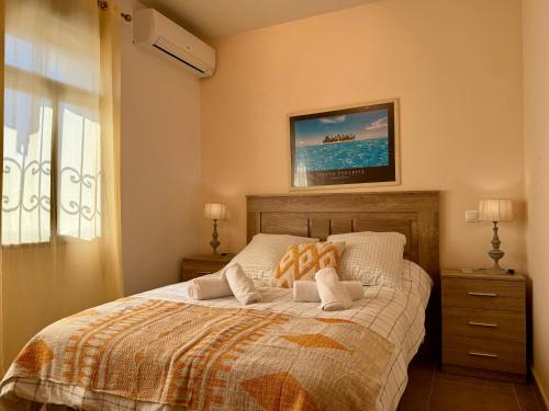 a bedroom with a bed with two night stands and a window at Casa Generoso en Navalcán in Navalcán