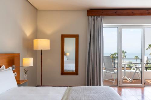 a hotel room with a bed and a mirror at Parador de Ceuta in Ceuta