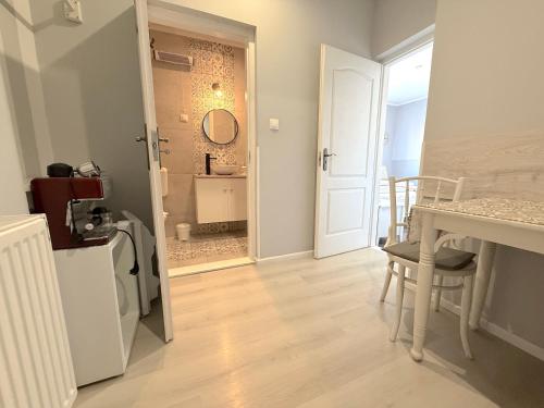 a room with a bathroom with a sink and a table at Villa Harmónia in Gyula