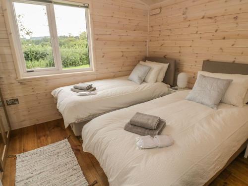 two twin beds in a room with two windows at Mallard in Ross on Wye