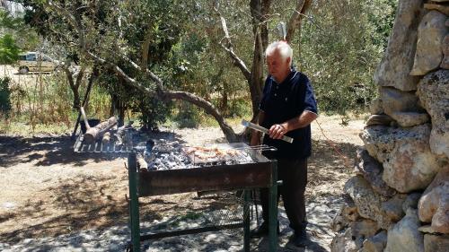 a man is cooking food on a grill at Agriturismo Tenuta La Siesta in Gallipoli