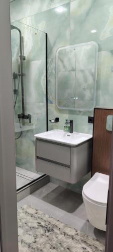 a bathroom with a sink and a toilet at AMARANT hotel in Baysun