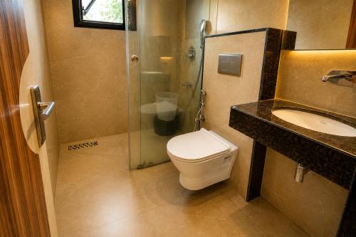 a bathroom with a shower and a toilet and a sink at Hotel kabras' inn in Mount Ābu