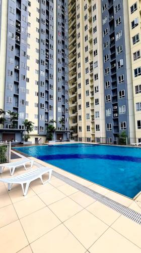 ein Schwimmbad vor einigen hohen Gebäuden in der Unterkunft Angel's Haven in Manila