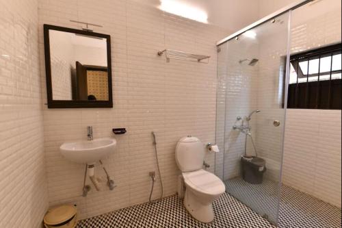 a bathroom with a toilet and a sink and a shower at Eennra Oiitijhyya in Kolkata