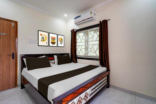 a bedroom with a bed and a window in it at Hotel O The Royal Guest Rooms in Vijayawāda