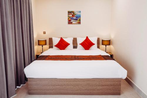 a bedroom with a large white bed with red pillows at Walk Street Hotel & Apartment in Phnom Penh