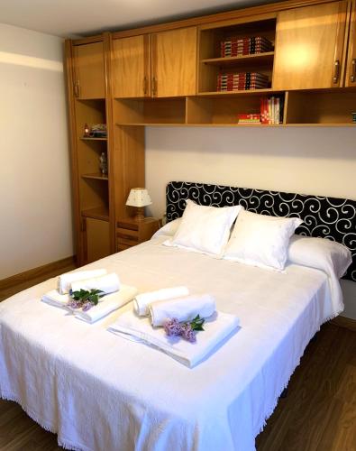 a large white bed with two towels on it at Villa Conde, Piscina, Barbacoa y Gran Patio in Prado