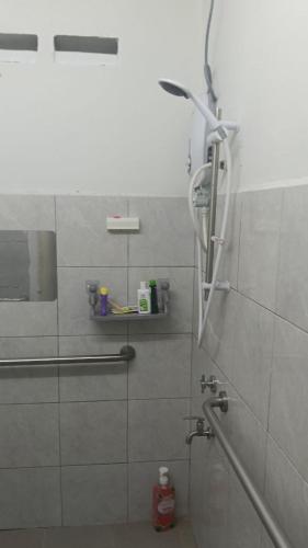 a shower in a bathroom with a glass door at Rembulan Guesthouse in Mersing