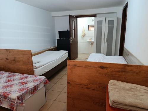 a small room with two beds and a bathroom at Fenix Grzybno pokoje pracownicze, rodzinne, typu standard,dłuższe pobyty in Grzybno