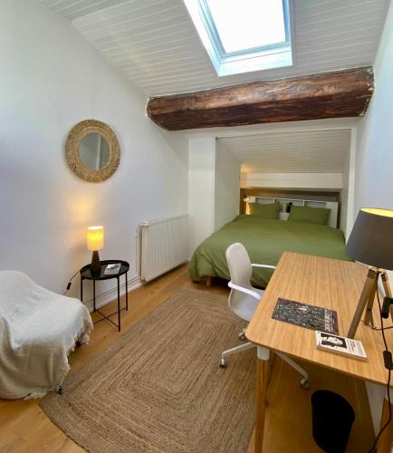 a bedroom with a bed and a desk with a table at Les Jardins Suspendus in Lyon