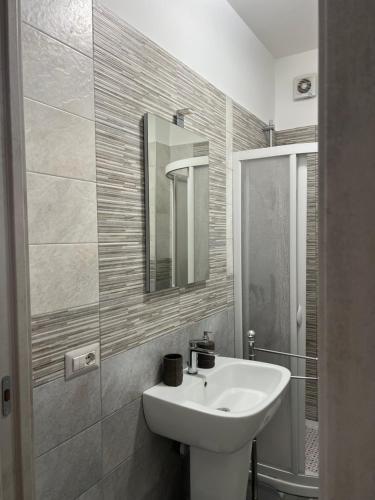 a white bathroom with a sink and a mirror at Paky' S House in Policoro