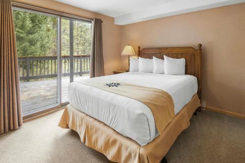 a bedroom with a large bed and a large window at Mountain House, A Vail Resorts Property in Keystone