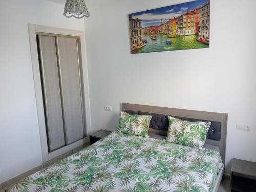 a bedroom with a bed and a painting on the wall at Le lagon de Hammamet in Hammamet