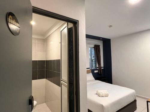 a small room with a bed and a shower at Hotel Double Star Klia in Sepang