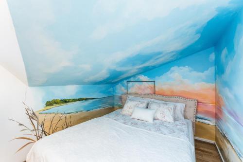 a bedroom with a bed with a painting of a beach at Rüütli Residents in Pärnu