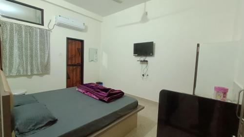 a room with a bed and a flat screen tv at Hotel Deeksha in Mandlā