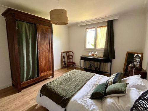 a bedroom with a bed and a table and a window at ATELIER Gîte Cahors in Pradines