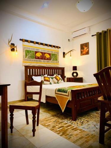 a bedroom with a large bed and a chair at Asoria Luxe Resort in Kegalle