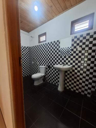 a bathroom with a black and white checkered wall at Nilaveli Shan Guest in Trincomalee