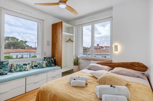 two beds in a bedroom with two windows at Villa Alekatele in La Tranche-sur-Mer