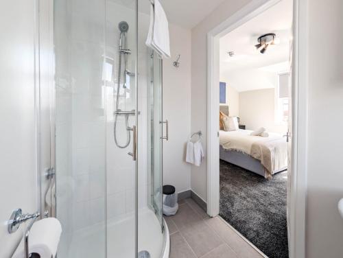 a bathroom with a shower and a toilet and a bed at The Marlowe in Southport