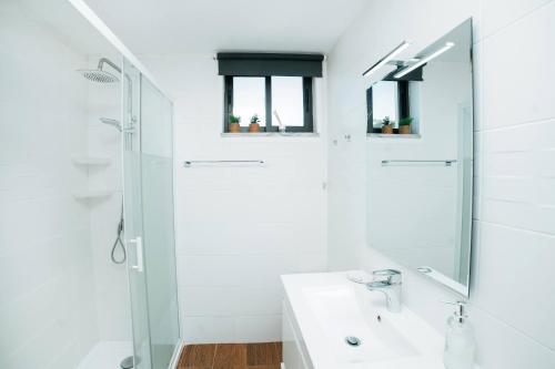 a white bathroom with a shower and a sink at Casa de Salgueiros in Canidelo