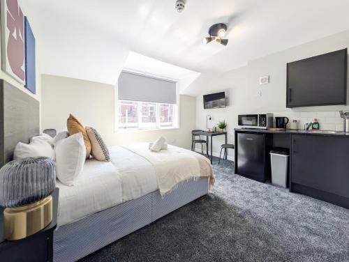 a bedroom with a large bed and a kitchen at The Marlowe in Southport