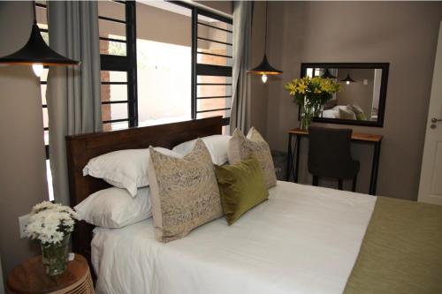 a bedroom with a bed with white sheets and pillows at Grey Corner Guesthouse in Postmasburg