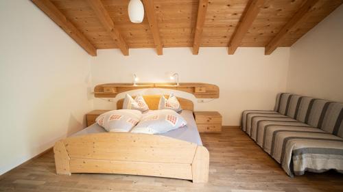 a bedroom with a wooden bed with pillows on it at Lechnerhof in Plaus