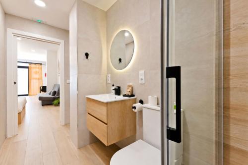 a bathroom with a sink and a toilet and a mirror at Apartamento Río Turia A in Valencia