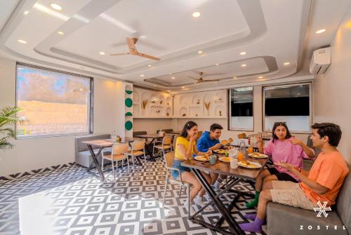 a group of people sitting at a table in a restaurant at Zostel Jaipur, MI Road in Jaipur