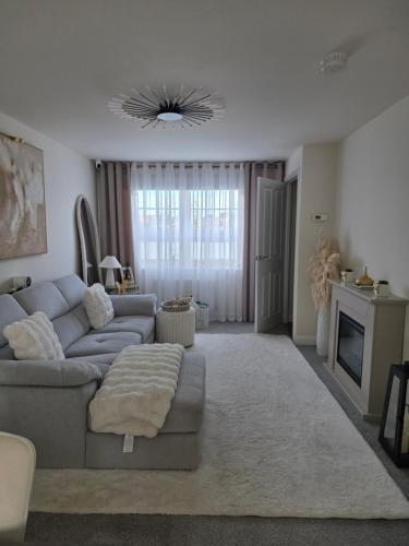 a living room with a couch and a fireplace at Hampton Water Rooms Peterborough in Peterborough