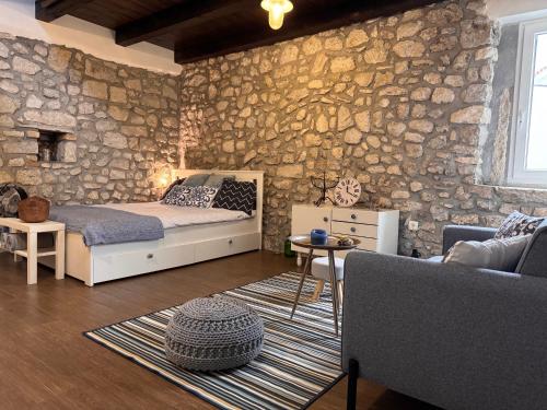 a bedroom with a bed and a stone wall at Old Town Apartment in Krk