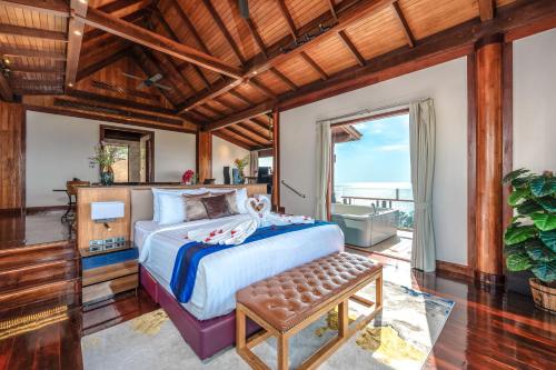 a bedroom with a bed and a large window at Luxury 4 pool Seaview 6 bedroom Villa on Surin Hill in Surin Beach