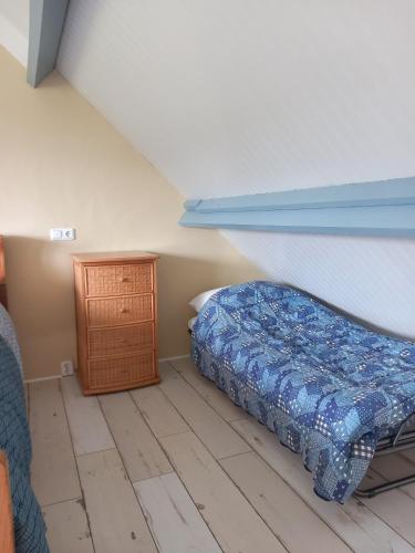 a bedroom with a bed and a wooden cabinet at B&B De koekoeksklok in IJsselmuiden