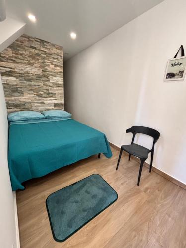 a bedroom with a green bed and a chair at La Suite da Esther in Adrano