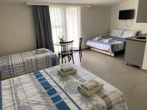 a bedroom with two beds and a kitchen and a table at Ressa Apart in Marmaris