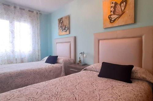 a bedroom with two beds and a window at Apartamento Playa Foz in Foz