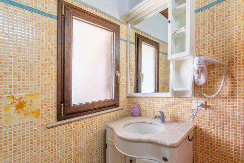 a bathroom with a sink and a mirror at Jungle Holiday Apartment in Avola