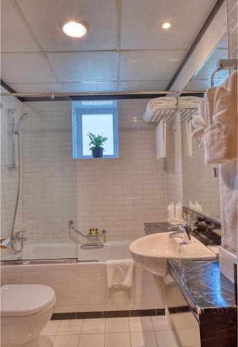 a bathroom with a tub and a toilet and a sink at Hotel Vasudha Inn-Near International Airport Delhi in New Delhi