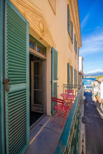 two red chairs on a balcony of a building at Hotel POZZO DI BORGO in Ajaccio