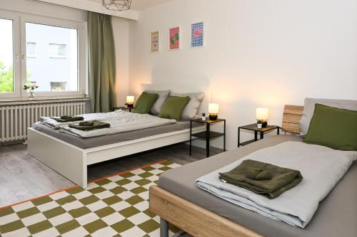 a bedroom with two beds and a checkered floor at Stilvolles Apartment im Bochumer Stadtkern in Bochum