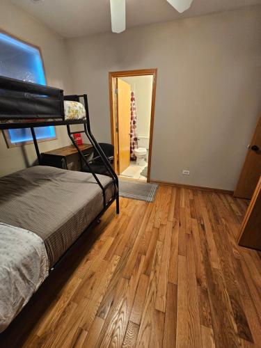 a bedroom with a bed and a wooden floor at 5430 Happy Home in Chicago