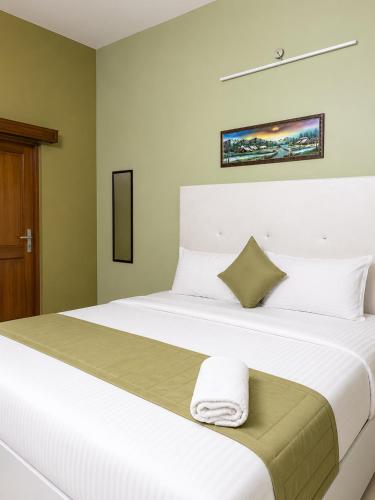 a bedroom with a large white bed with a towel on it at Royal Inn in Lucknow
