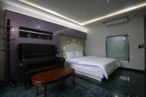 a hotel room with a bed and a chair at Inca Motel in Daejeon
