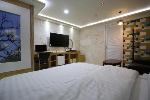 a bedroom with a bed and a desk and a television at Inca Motel in Daejeon