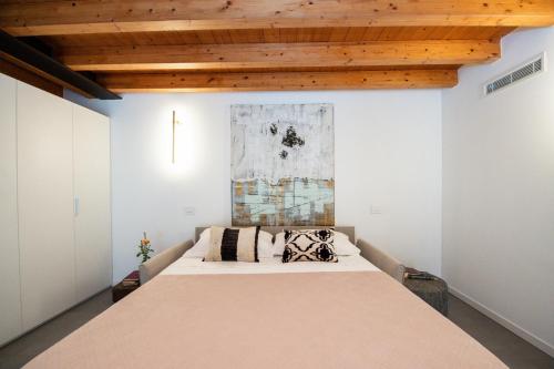 a large bed in a room with a wooden ceiling at Maison Selva - Palazzo Cervi Duplex Superior in Salò